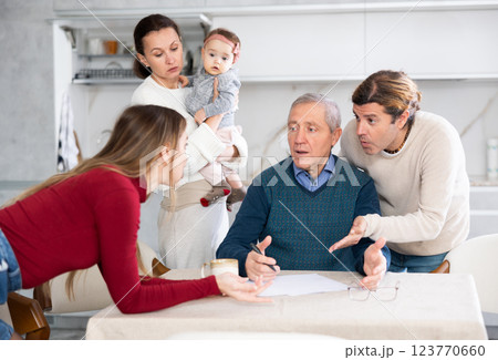 People of different generations argue with each other and show an mature father how to fill out documents correctly People of different generations argue with each other and show an mature father how to fill out documents correctly 123770660