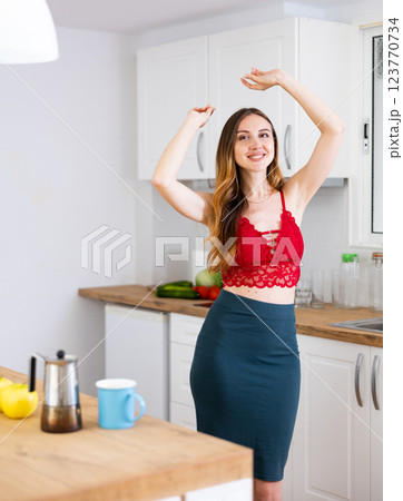 Happy woman dancing in the kitchen at home Happy woman dancing in the kitchen at home 123770734
