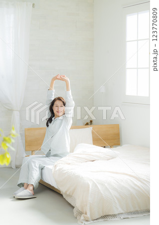 ベッドでストレッチするシニア女性 ベッドでストレッチするシニア女性 123770809