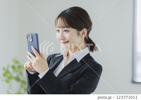 スマホを操作するスーツの女性　 123771011