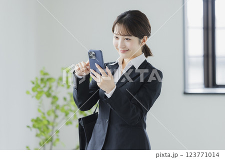 スマホを操作するスーツの女性 スマホを操作するスーツの女性 123771014