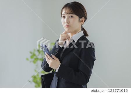 スマホを操作するスーツの女性　 123771016