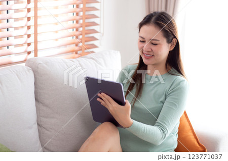 Young asian business woman using tablet computer for relax and check social media online. 123771037
