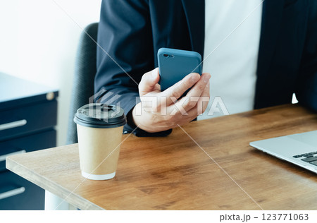 パソコンとスマホを操作する男性 123771063