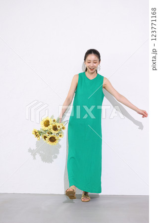 ひまわりの花束を持つ笑顔の女性 123771168