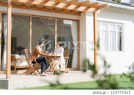 広いテラスでくつろぐカップル 広いテラスでくつろぐカップル 123771421