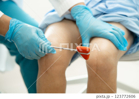 Asian doctor physiotherapist examining, massaging and treatment knee and leg of senior patient in orthopedist medical clinic nurse hospital. 123772606