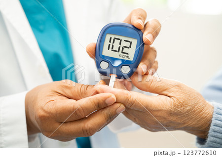 Doctor check diabetes from finger blood sugar level with finger lancet. Doctor check diabetes from finger blood sugar level with finger lancet. 123772610