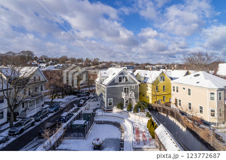 Aerial view of houses in Porter Square, MA, covered in winter snow with white clouds and blue sky in background Aerial view of houses in Porter Square, MA, covered in winter snow with white clouds and blue sky in background 123772687