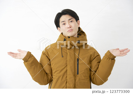 ダウンジャケットを着た男性 呆れる 白背景 カメラ目線 ダウンジャケットを着た男性 呆れる 白背景 カメラ目線 123773300
