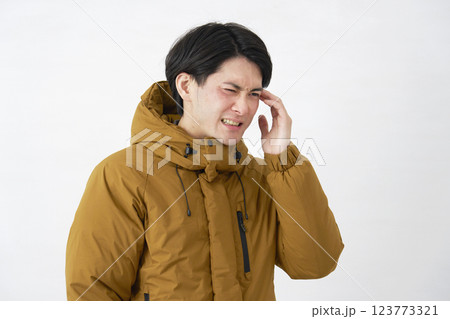 ダウンジャケットを着た男性　頭痛　白背景 123773321