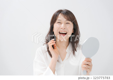 手鏡を持つ笑顔のミドル女性 123773783