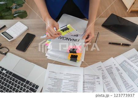 Accountant sorting financial documents and reports at a desk 123773937