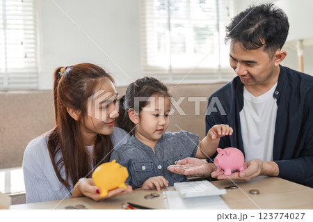 Engaged family discussing savings and budgeting with piggy banks at home. Engaged family discussing savings and budgeting with piggy banks at home. 123774027