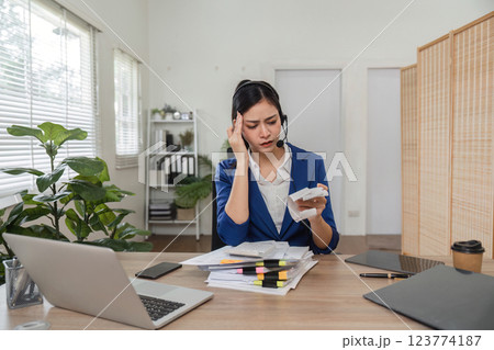 Stressed accountant dealing with tax calculations and paperwork, illustrating the challenges of financial management. 123774187