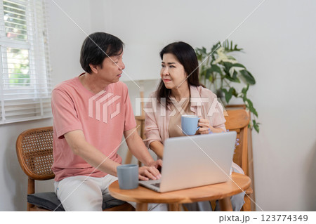 Older couple discussing online activities while enjoying coffee at home. 123774349