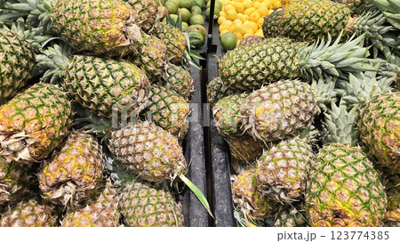 Fresh Pineapples in a Vibrant Market Display of Tropical Fruits, Colorful display of fresh, ripe pineapples at a market showcasing a tropical atmosphere Fresh Pineapples in a Vibrant Market Display of Tropical Fruits, Colorful display of fresh, ripe pineapples at a market showcasing a tropical atmosphere 123774385