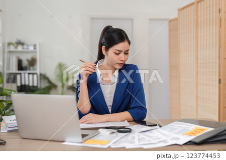 Businesswoman accountant deep in thought while reviewing financial documents. Businesswoman accountant deep in thought while reviewing financial documents. 123774453