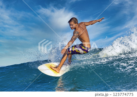 Male surfer on a blue wave Male surfer on a blue wave 123774775