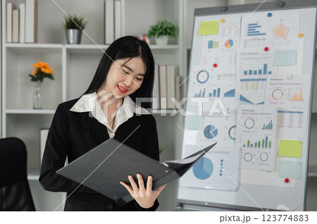 Businesswoman reviewing financial reports and budgets in her office. Businesswoman reviewing financial reports and budgets in her office. 123774883