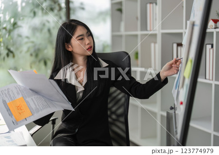 Accountant analyzing tax documents and financial charts in a modern office setting. Accountant analyzing tax documents and financial charts in a modern office setting. 123774979