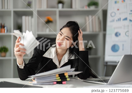 Businesswoman deeply focused on tax documents, navigating the complexities of financial reporting. 123775089