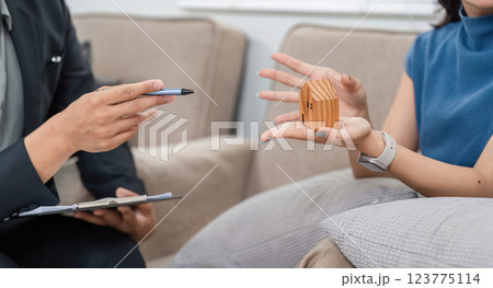 Real estate consultation with clients showcasing wooden house models 123775114