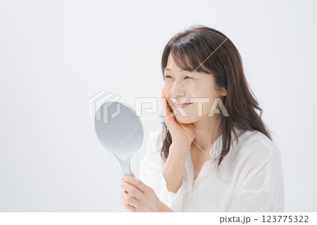 手鏡を持つ笑顔のミドル女性 123775322