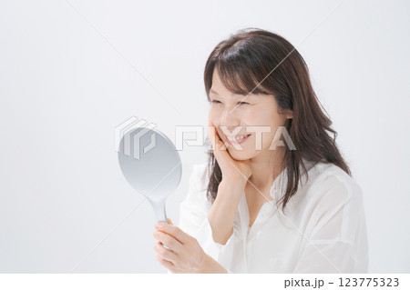 手鏡を持つ笑顔のミドル女性 123775323