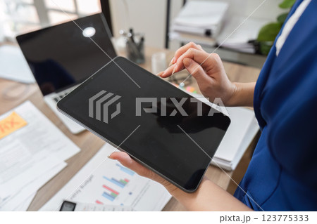 Accountant reviewing financial data on tablet in modern office Accountant reviewing financial data on tablet in modern office 123775333