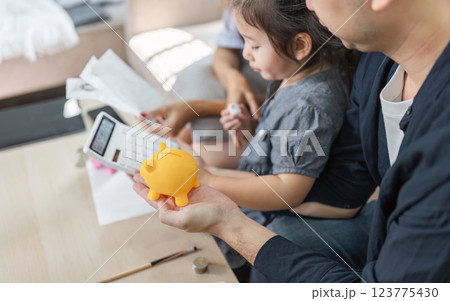 Family member holding a piggy bank, emphasizing savings and financial planning. 123775430