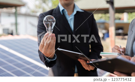 Business collaboration. Professionals showcasing sustainable innovations outdoors. 123775432