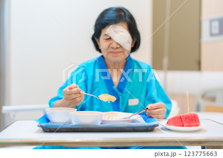 Senior Woman eating food after eye surgery in hospital . Eye disease, Cataract,  Glaucoma, Age Related Macular Degeneration, Diabetic Retinopathy, Lasik, World Glaucoma day and health treatment 123775663