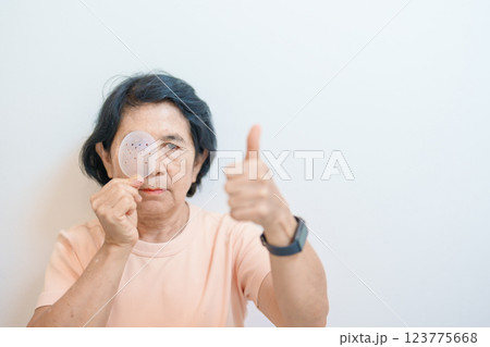 Elderly Woman with eye protective shield after eye surgery. Eye disease, Cataract,  Glaucoma, Age Related Macular Degeneration, Diabetic Retinopathy, Vitreous, Lasik, World Glaucoma day and health 123775668