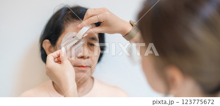 Senior Woman during eye protecting by shield after eye surgery. Eye disease, Cataract, Glaucoma, Age Related Macular Degeneration, Diabetic Retinopathy, Vitreous, Lasik, World Glaucoma day and health Senior Woman during eye protecting by shield after eye surgery. Eye disease, Cataract, Glaucoma, Age Related Macular Degeneration, Diabetic Retinopathy, Vitreous, Lasik, World Glaucoma day and health 123775672