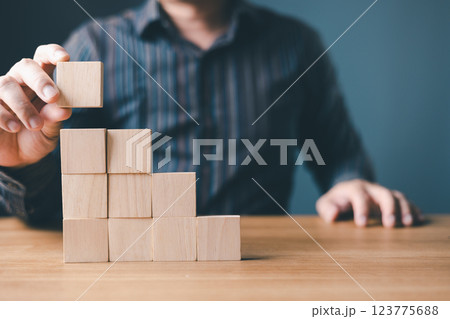 hand of a businessman stacking wood empty ten blocks with copy space for text or symbols, development concept for growth success process. hand of a businessman stacking wood empty ten blocks with copy space for text or symbols, development concept for growth success process. 123775688