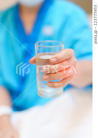 Senior woman with Tremor hand during taking glass of water in hospital. Parkinson disease April awareness month, Carpal Tunnel Syndrome, rheumatoid and brain injury and Neurological disorder concept Senior woman with Tremor hand during taking glass of water in hospital. Parkinson disease April awareness month, Carpal Tunnel Syndrome, rheumatoid and brain injury and Neurological disorder concept 123775955