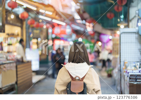 woman traveler visiting in Taiwan, female Tourist with backpack sightseeing and shopping at Jiufen Old Street market. Popular landmark and attractions near Taipei City. Travel and Vacation concept woman traveler visiting in Taiwan, female Tourist with backpack sightseeing and shopping at Jiufen Old Street market. Popular landmark and attractions near Taipei City. Travel and Vacation concept 123776386