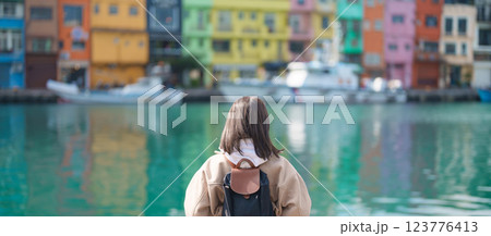 woman traveler visiting in Taiwan, female Tourist with backpack sightseeing at Keelung, Colorful Zhengbin Fishing Port. Popular landmarks and attractions near Taipei City.  Asia Travel concept 123776413