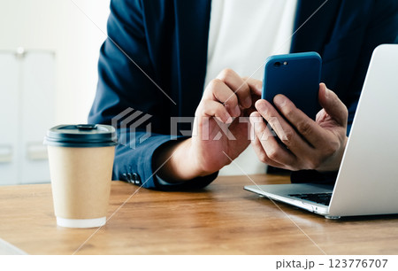 パソコンとスマホを操作する男性 パソコンとスマホを操作する男性 123776707