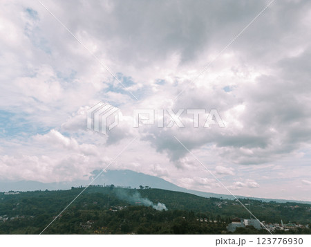 Clouds hovering over a mountain in a village with an overcast sky, Clouds hovering over a mountain in a village with an overcast sky, 123776930