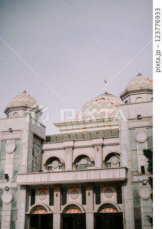 The serene domes of a mosque rise against a soft sky, 123776933