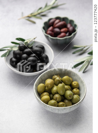 Black, green and kalamata olives with olive branches on marble background 123777420