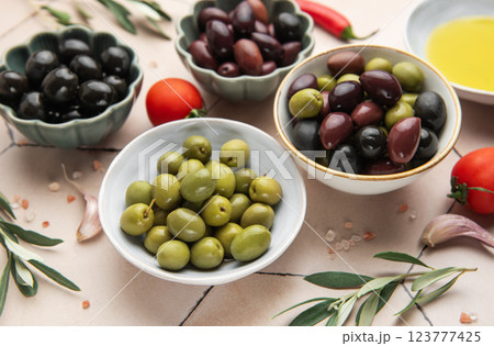 Bowls of green and black olives with tomatoes, garlic, olive oil, salt and pepper flakes 123777425