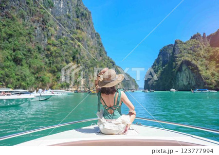 Woman tourist on boat trip, happy traveller relaxing at Pileh lagoon on Phi Phi island, Krabi, Thailand. Exotic landmark, destination Southeast Asia Travel, summer vacation and holiday concept Woman tourist on boat trip, happy traveller relaxing at Pileh lagoon on Phi Phi island, Krabi, Thailand. Exotic landmark, destination Southeast Asia Travel, summer vacation and holiday concept 123777994
