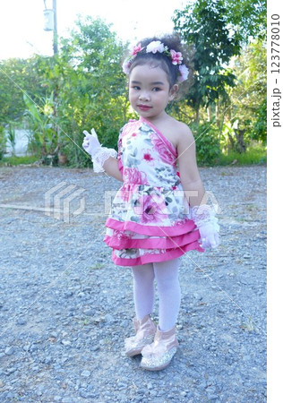 Portrait of a little girl in a pink dress and pink skirt on the street Portrait of a little girl in a pink dress and pink skirt on the street 123778010