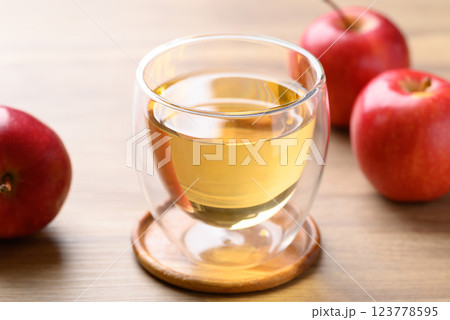 Glass of apple cider and red apple fruit on wooden background 123778595