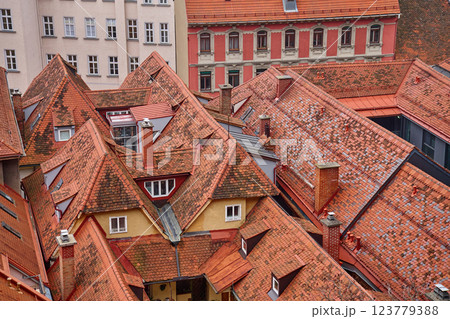 Scenic aerial view of historic European rooftops covered with red clay tiles and chimneys. Old town architecture and traditional cityscapes in European city. Panoramic view of Graz, Austria 123779388