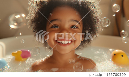 Joyful little girl enjoying a bubble bath filled with colorful toys and playful bubbles in a cozy bathroom setting 123780399