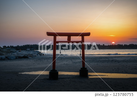 日の出を迎える海岸の鳥居と印象的な岩 日の出を迎える海岸の鳥居と印象的な岩 123780755